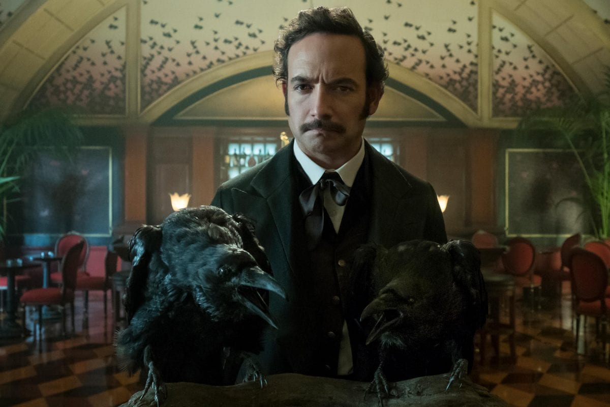 Poe standing in front of two ravens