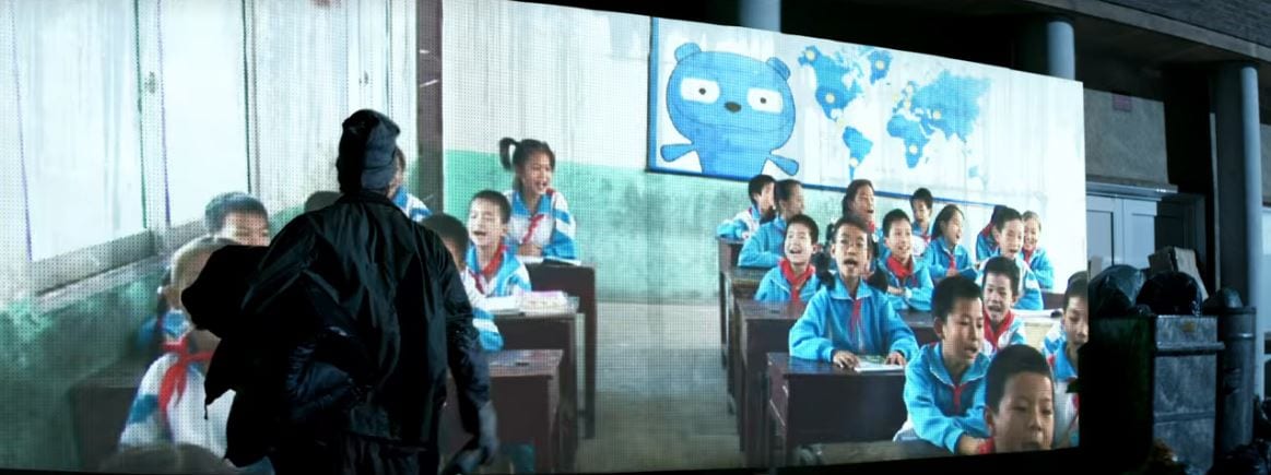 Asian children in a classroom with Waldo on a screen