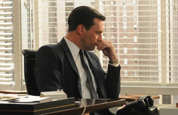 Don Draper with his hand to his chin looking worried in Mad Men