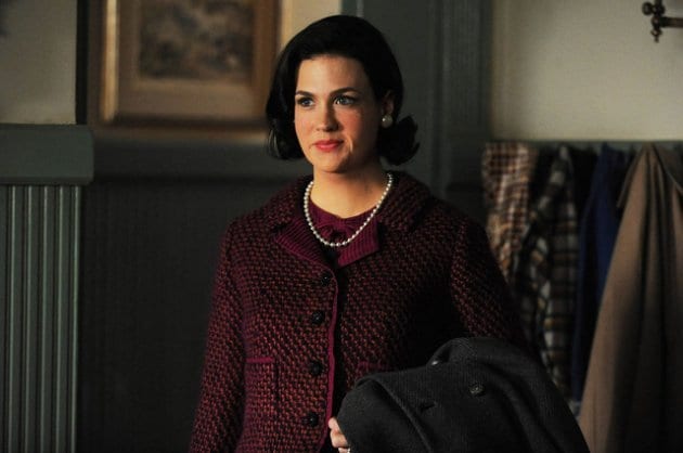 betty draper with dark hair, extra weight after learning she has cancer, but is smiling