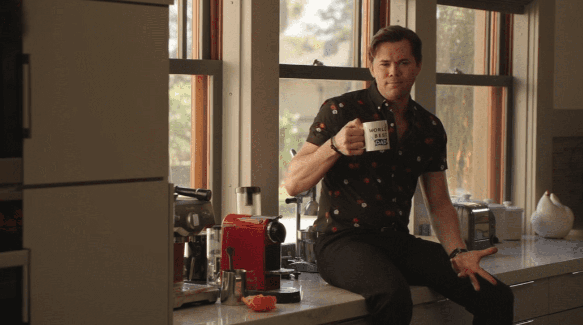 David Patton (Andrew Rannells) drinks from Alex Myers' (Ron Livingston) World's Best Dad mug while talking to him The Romanoffs "Bright and High Circle"