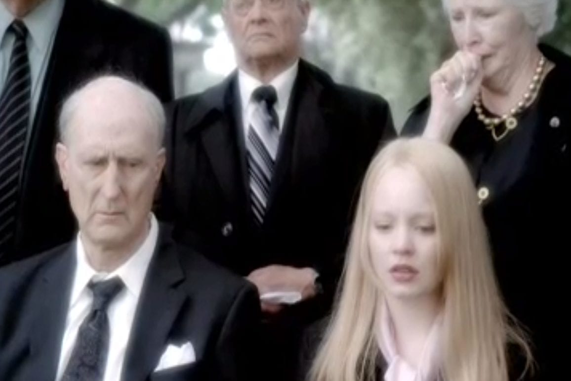 Older versions of George and Claire at a funeral