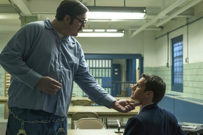 Ed Kemper (Cameron Britton) towers over agent Holden Ford (Jonathan Groff) during an interview in Mindhunter Season 1