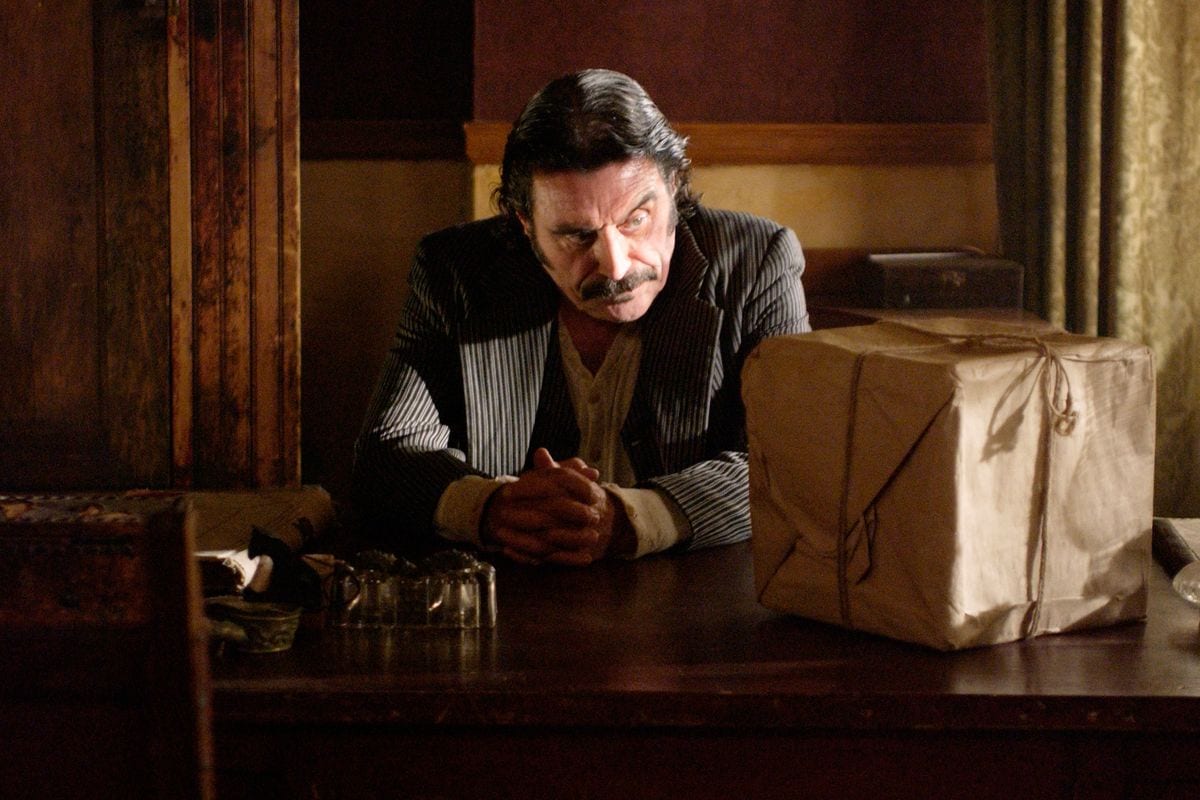 Al looking at the box on his desk in HBO's Deadwood