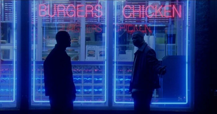 D'Angelo and Wee-Bey stand in front of the neon signs of a restauant in The Wire's pilot episode