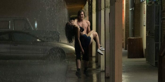 TJ (Griffin Powell-Arcand) carries Sasha (Sivan Alyra Rose) in the rain after her heart attack