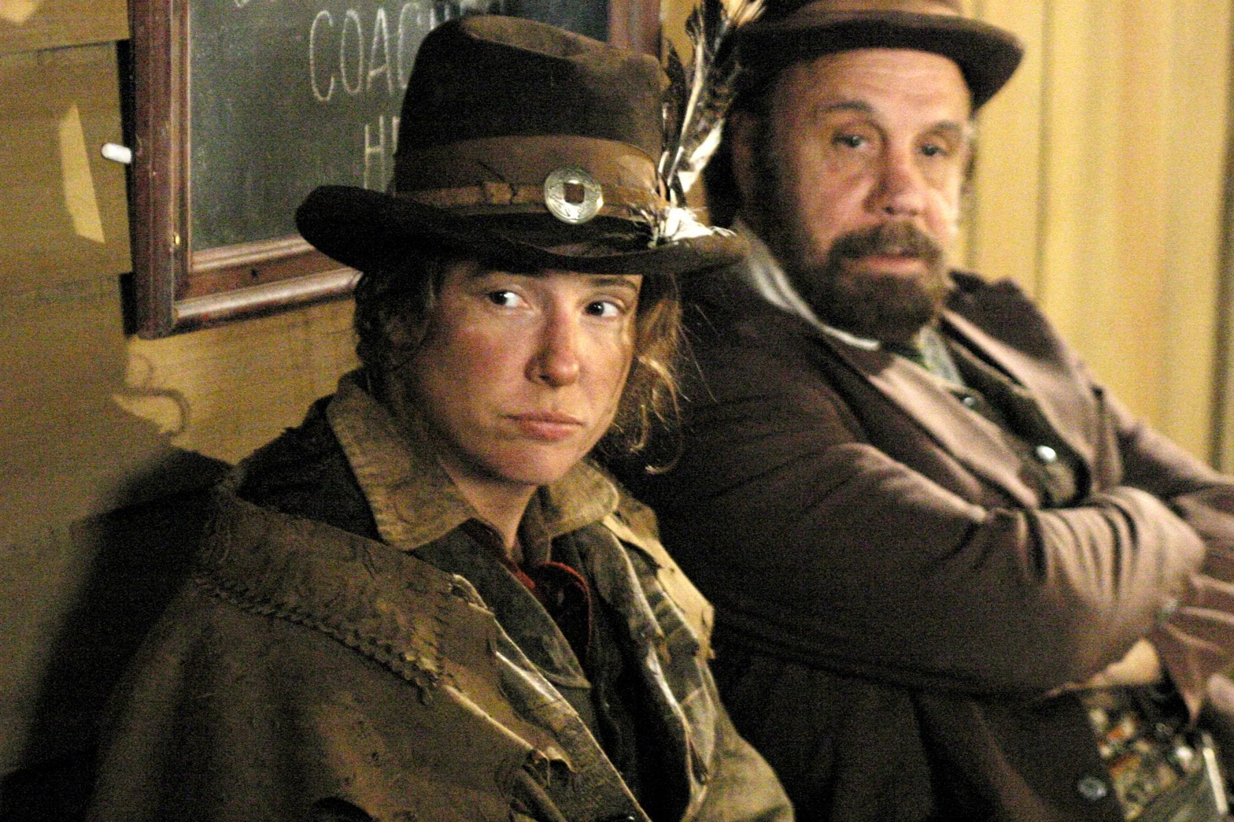 Jane sits next to Charlie Utter in Deadwood