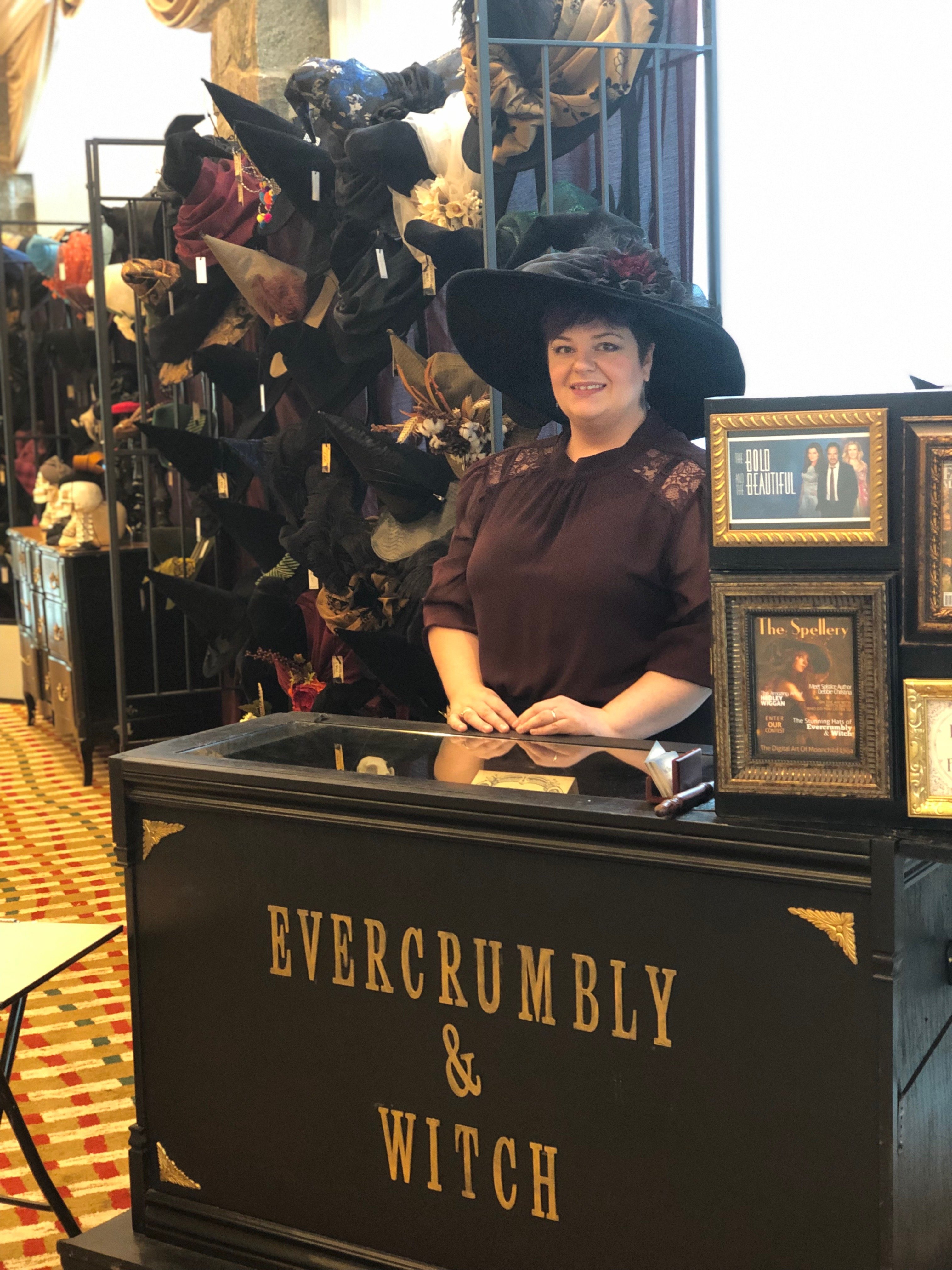 The proprietor of vendor Evercrumbly and Witch, at her booth, selling witch's hats