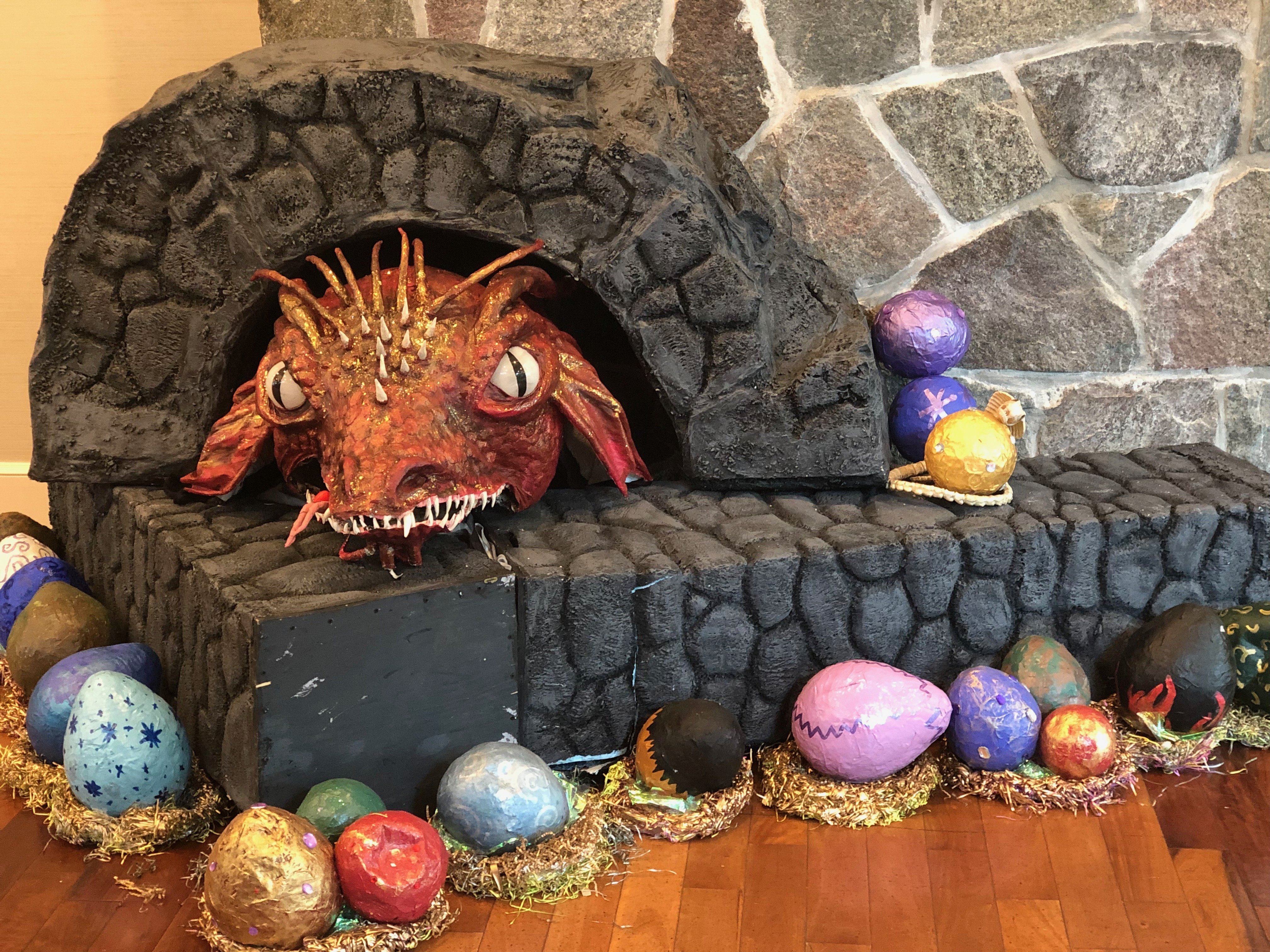 A homemade dragon, surrounded by eggs, decorating the con area