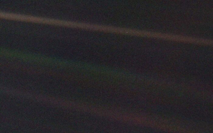 photo taken by Voyager 1 of Earth, seen as a pale blue dot in the top beam of light