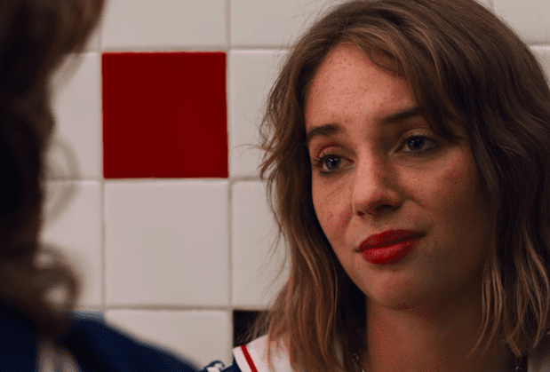 A teary eyed Robin(Maya Hawke) sits a gainst the bathroom tiles of Stranger Things'Starcourt Mall.