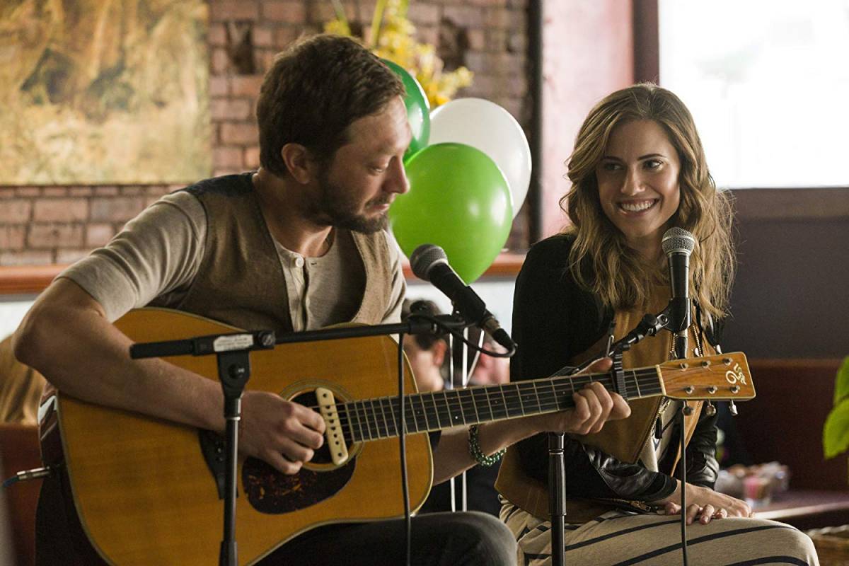 Desi (Ebon Moss-Bachrach) and Marnie (Allison Williams) perform an acoustic set in a cafe in Girls