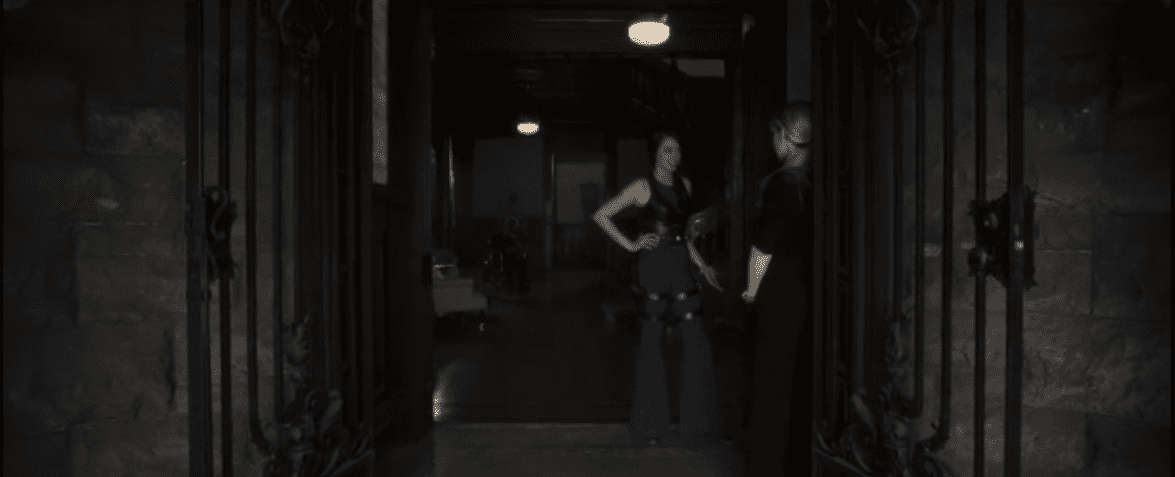 Kerry and Syd stand in the doorway of the house debating the morality of killing baby David