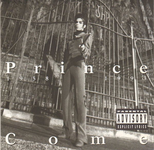 Prince is standing in front of a wrought iron gate in a predominantly gray album cover for Come
