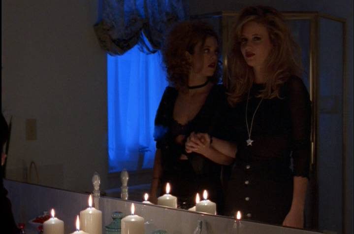 Terri and Margi stand in front of a bathroom mirror with lit candles playing Bloody Mary.