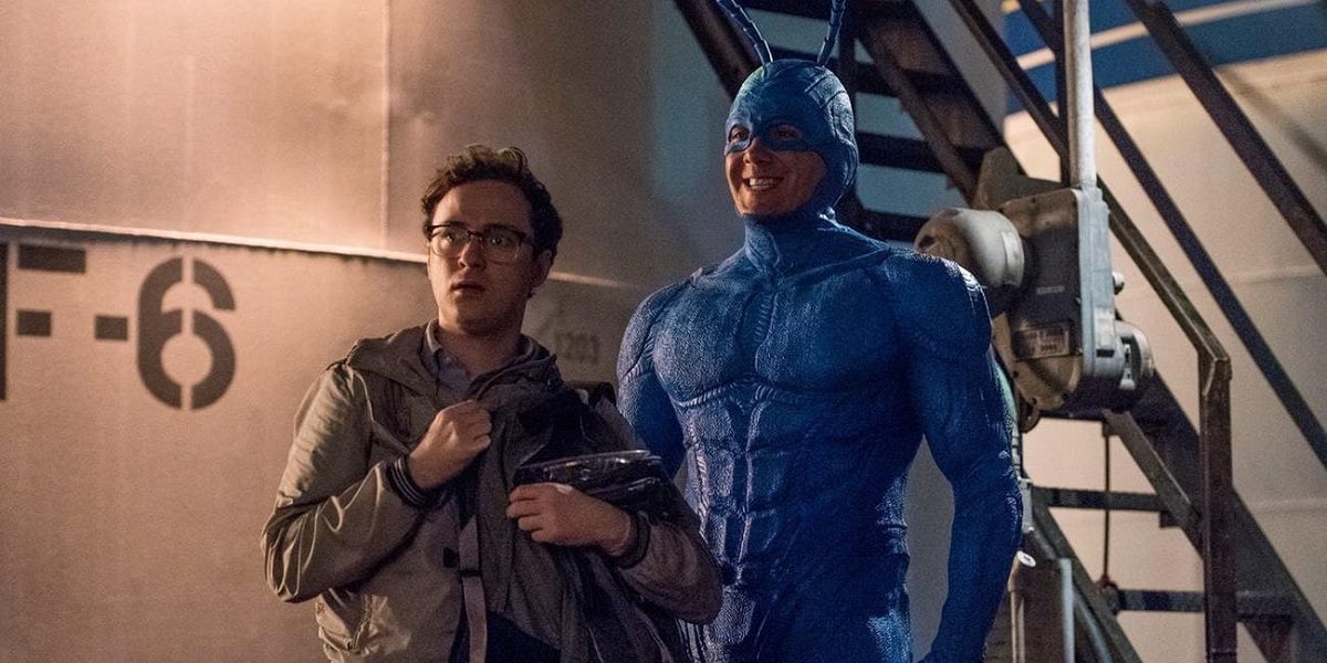 The Tick and Arthur (not in costume) stand together in an industrial area.