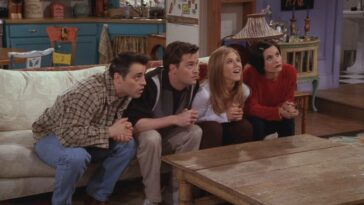 Joey, Chandler, Rachel and Monica stare intently at the TV from their couch in Monica's appartment.