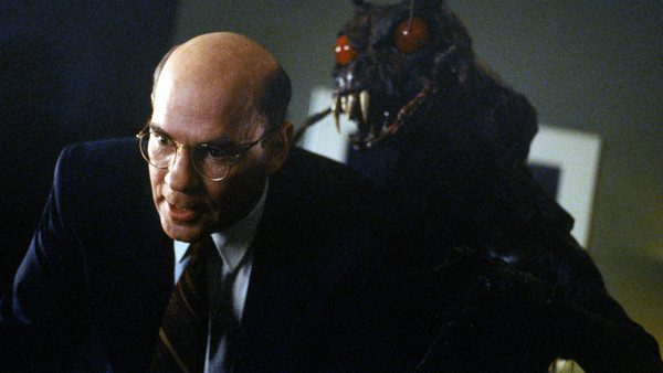 The insect monster, with big red eyes and giant fangs visible, leers over Assistant Director Skinner's shoulder.