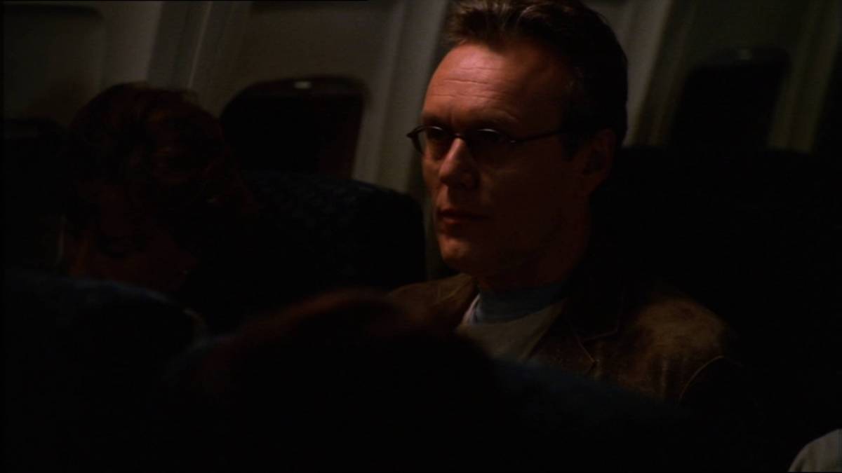 Giles sits on a plane.