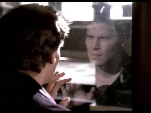 Angel looks at his own reflection in a mirror