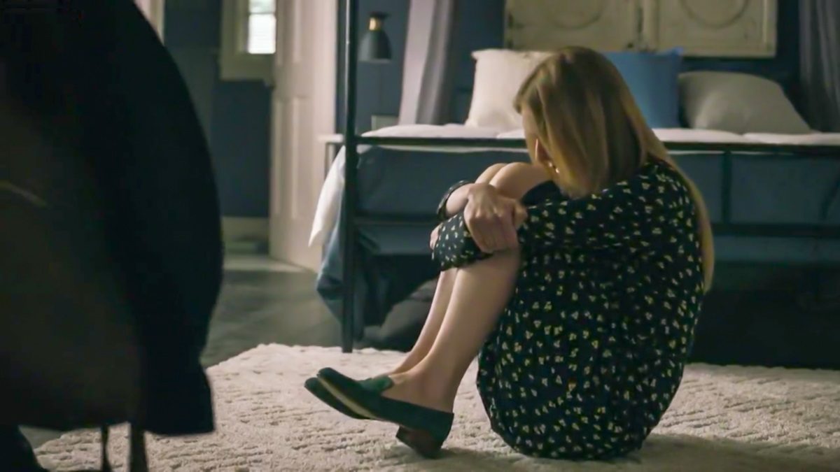 Holly sits on the floor in a bedroom, curled up and rocking. [Mr. Mercedes S03E06]