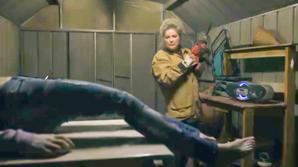 Alma stands in her shed, Danielle's frozen body in the foreground, with a small chainsaw in hand.