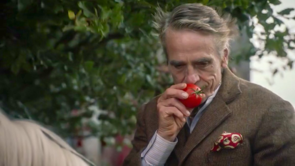 Watchmen S1E2 - The Lord of a Country Manor sniffs a tomato he has just plucked from a tree.