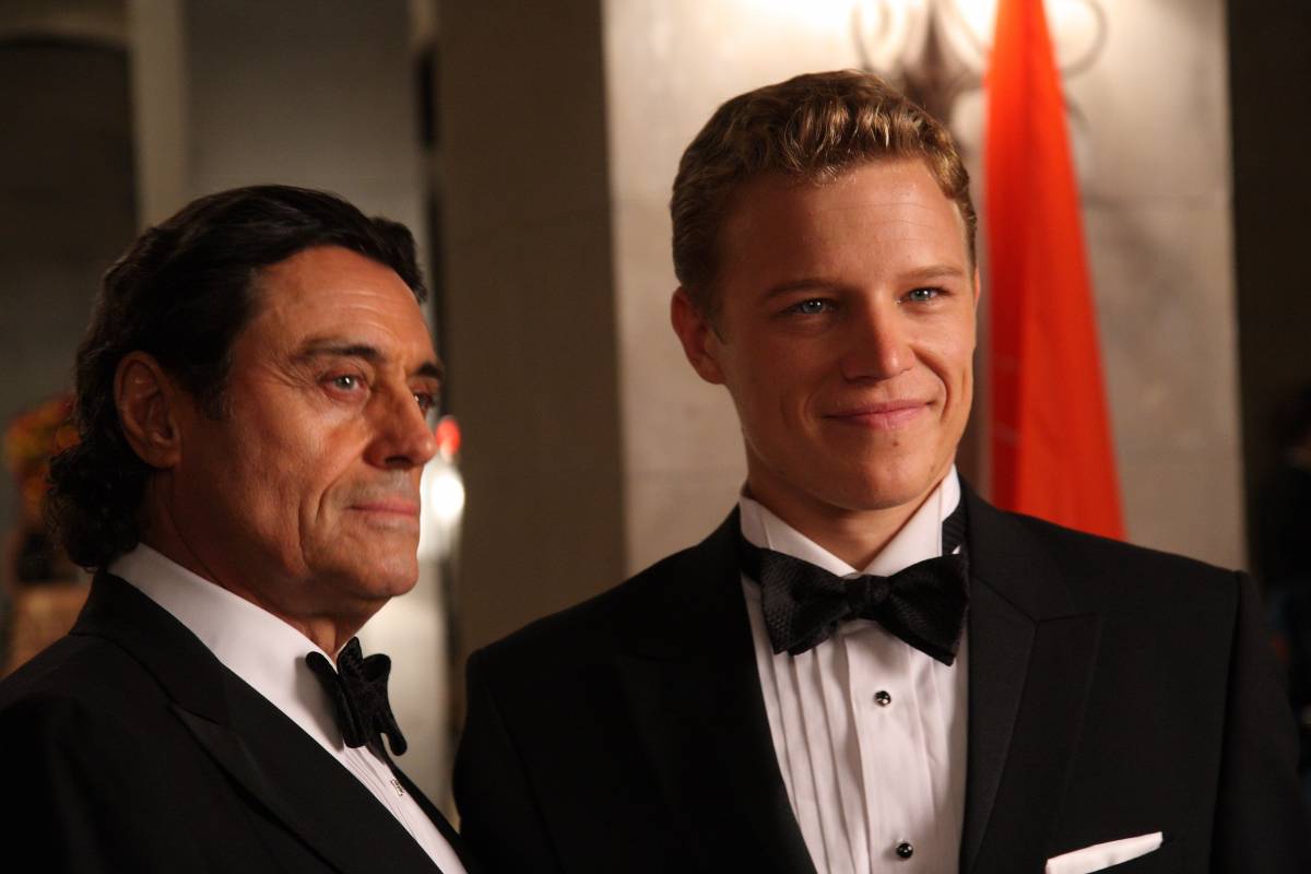 King Silas and David, both wearing black tie, are looking at something offscreen. David is smiling.