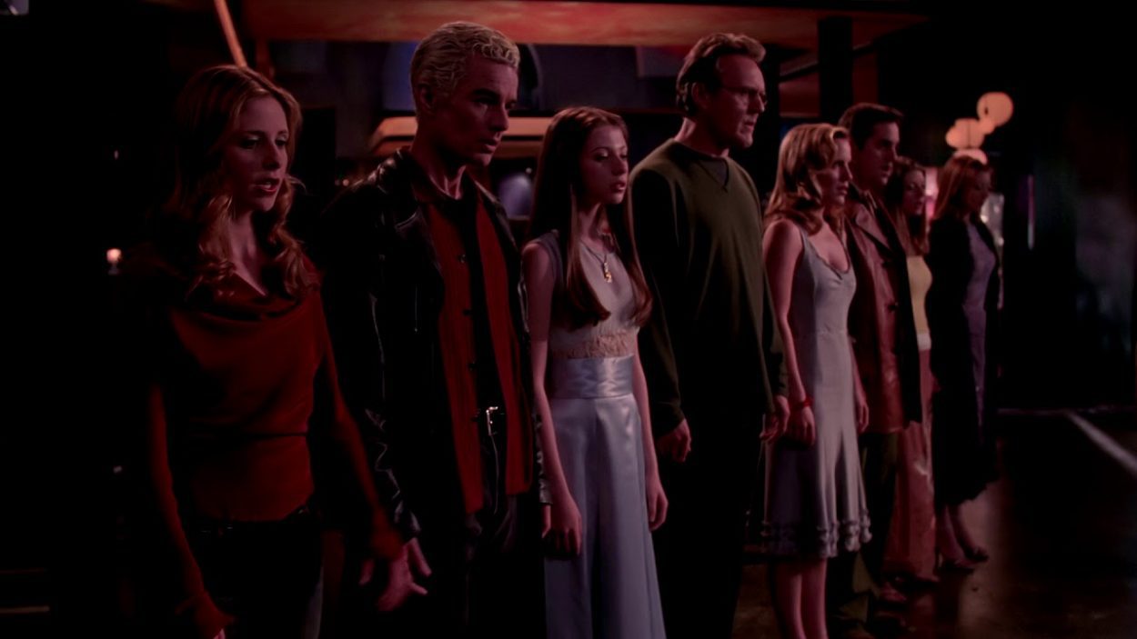 Buffy, Spike, Dawn, Giles, Anya, Xander, Tara and Willow stand hand in hand during Where Do We Go From Here