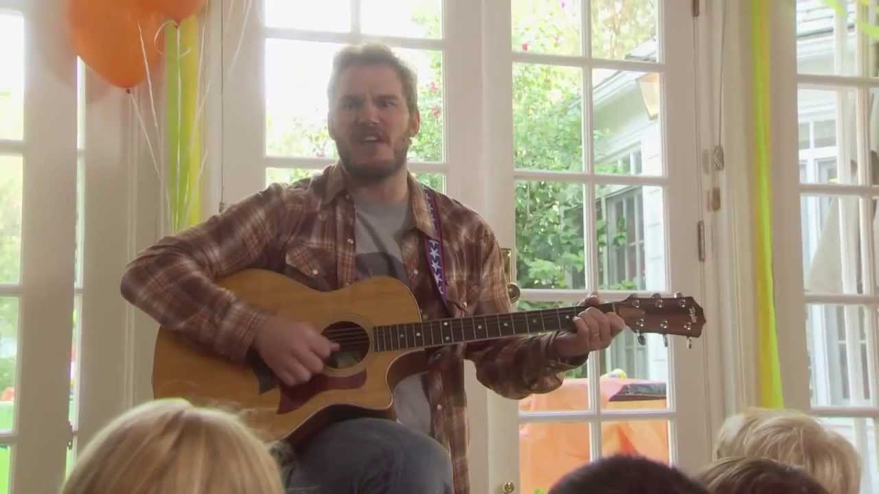 Flannel-wearing Andy plays guitar at a kids' party