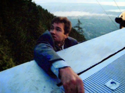 Mulder hangs on from the top of the cable car as he's taken up to the top of a mountain.