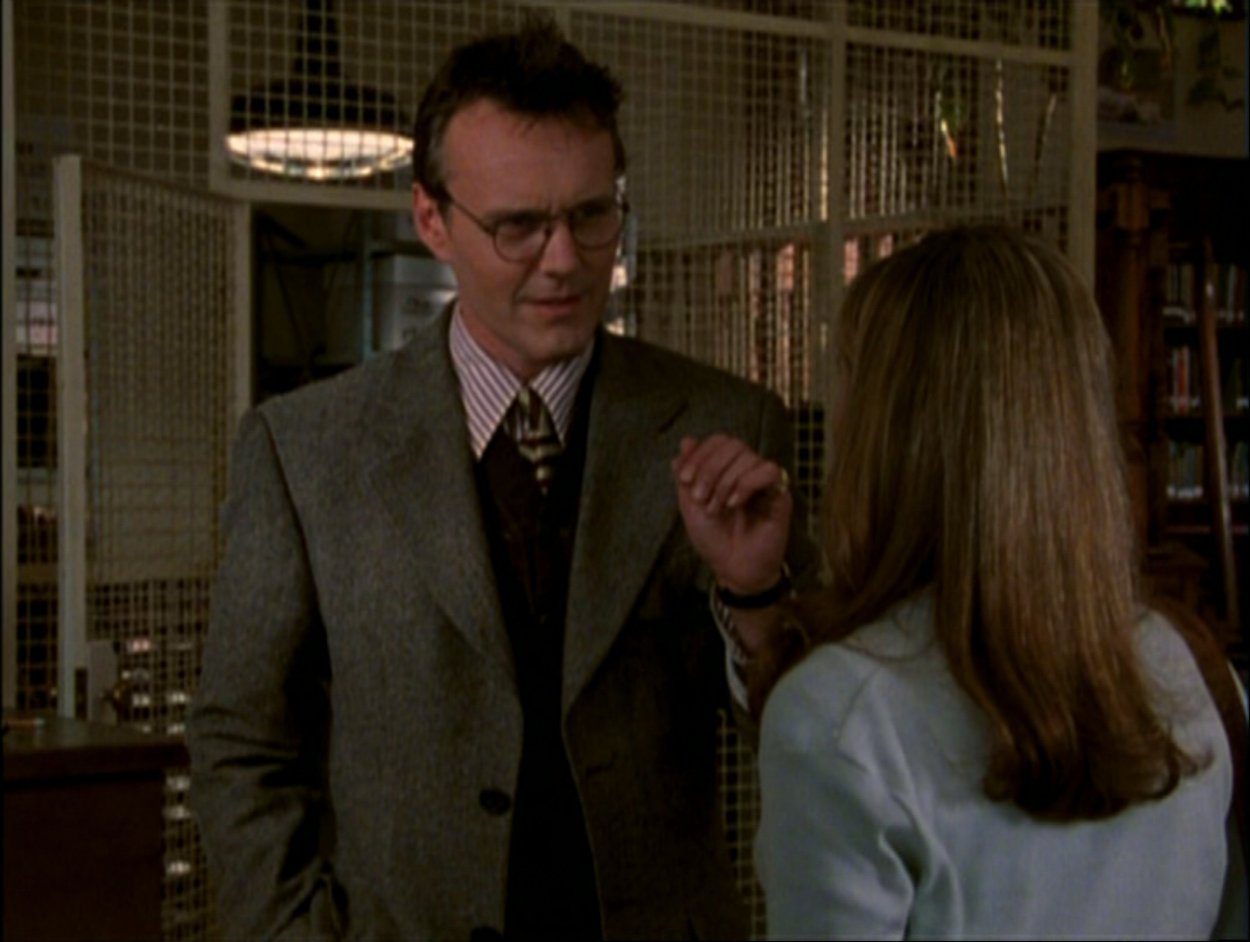 Giles talks to Buffy in the library