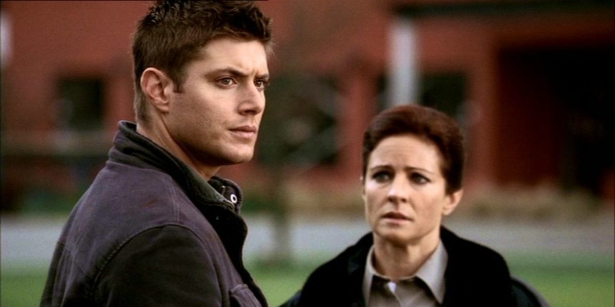 Dean staring at something off to the right with Sheriff Kathleen staring at him in concern 