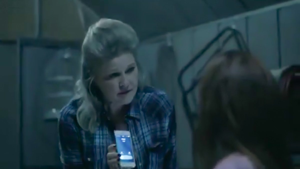 Alma holds a ringing cell phone up to Marjorie