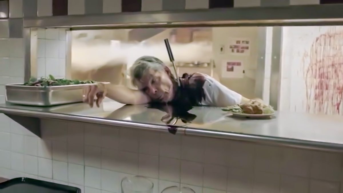 A diner cook lies dead over the counter, a large knife in his back