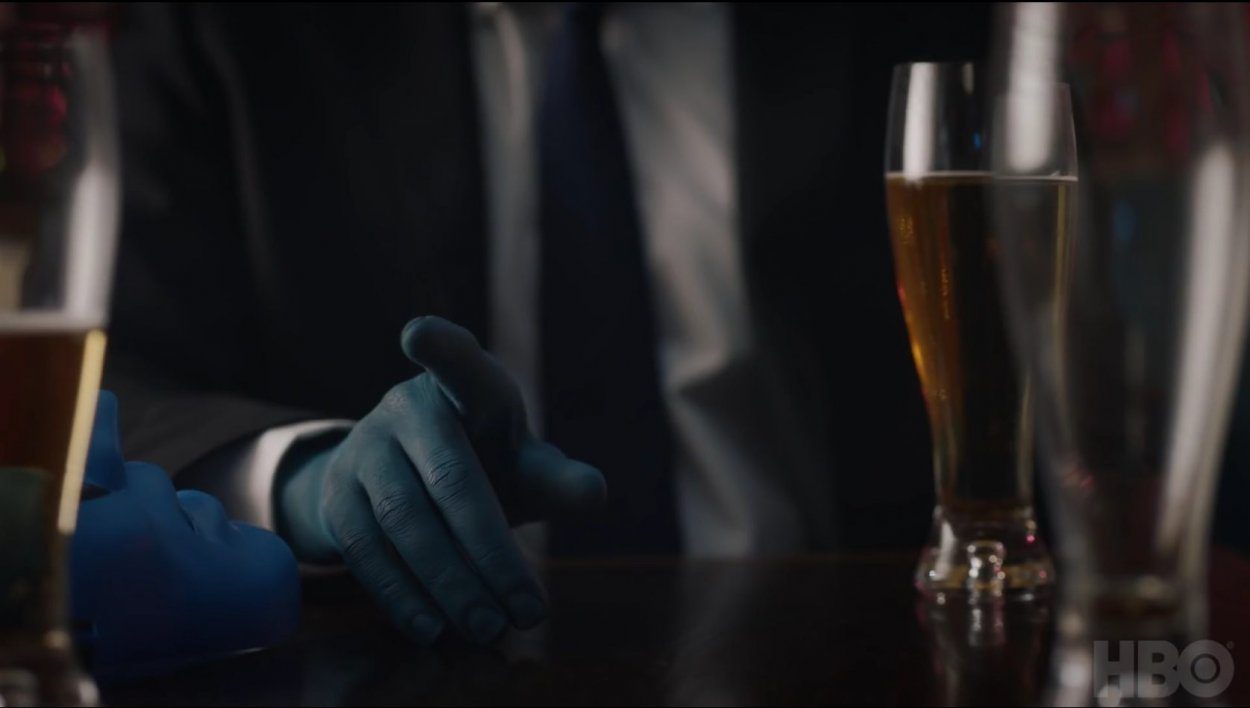 Watchmen - A blue hand belonging to a man in a black suit