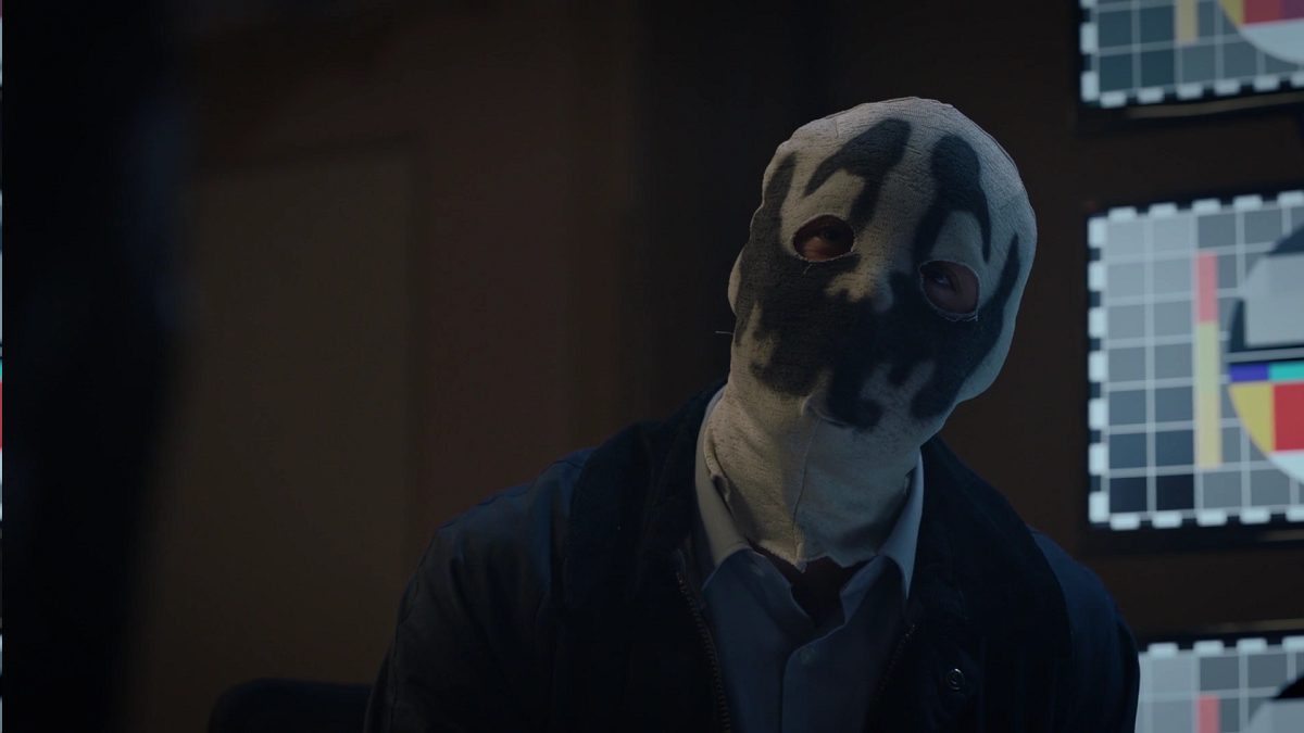 Watchmen - Senator Keene in a Rorschach mask, with video monitors behind him