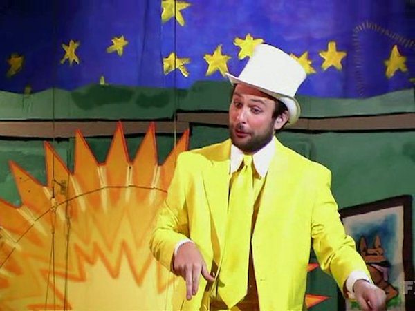 Charlie in a yellow suit with top hat and cane performing his surprise number at the end of The Nightman Cometh