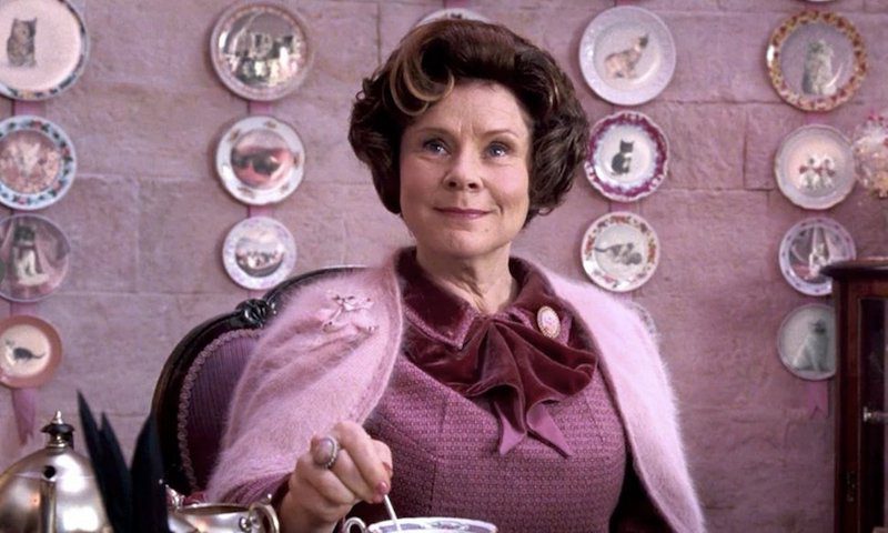Imelda Staunton as her Harry Potter character wearing pink and stirring tea