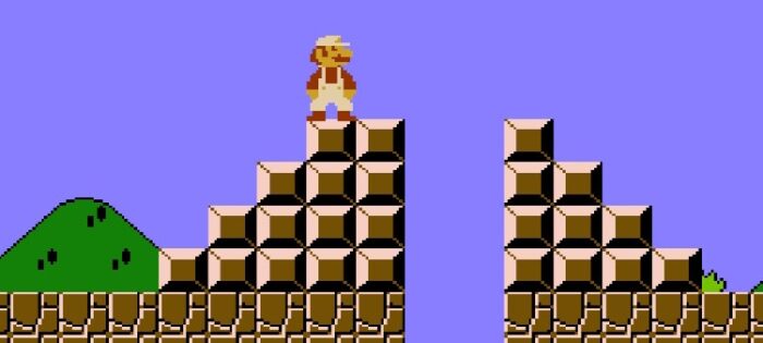 Mario stands on top of one stairway. There is a pit he needs to jump over to get to the other side alive.