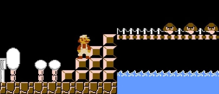 Mario stands before a bridge where three Goombas approach.