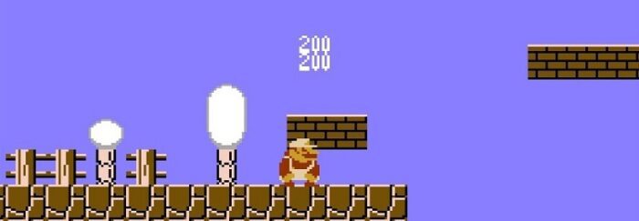 Super Mario slides under a brick and racks up coins.