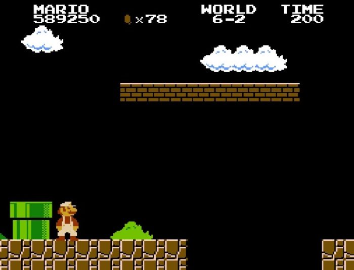 Super Mario stares down a very long jump in the darkness of World 6-2.