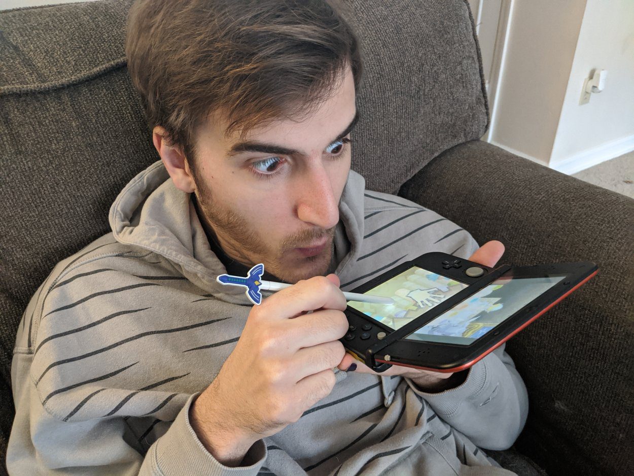 Sean, the author of the article blowing into his Nintendo DS to demonstrate the pan pipe playing mechanic in The Legend of Zelda: Spirit Tracks.