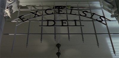 The gothic framework of the gate, its name Excelsis Dei is made out of thin iron