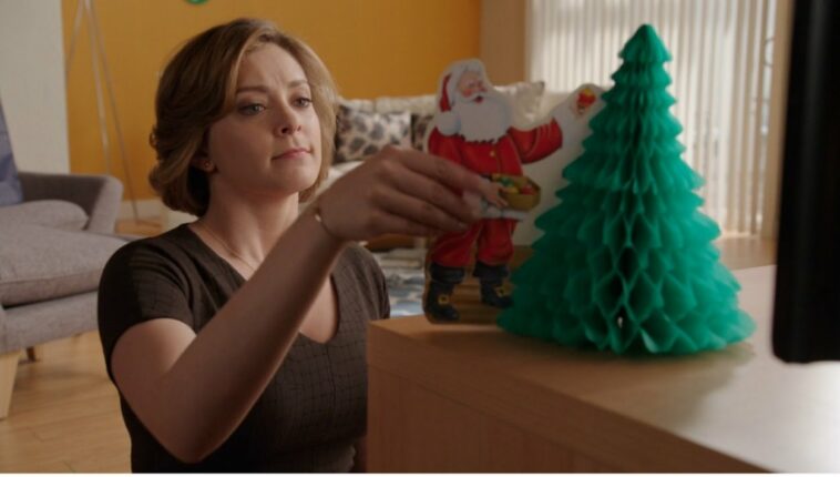 Rebecca puts a santa ornament next to a Christmas tree ornament