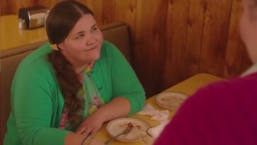 Twin Peaks Part 6 - Miriam sits smiling at a booth in the RR Diner, two polished off pie plates sitting in front of her