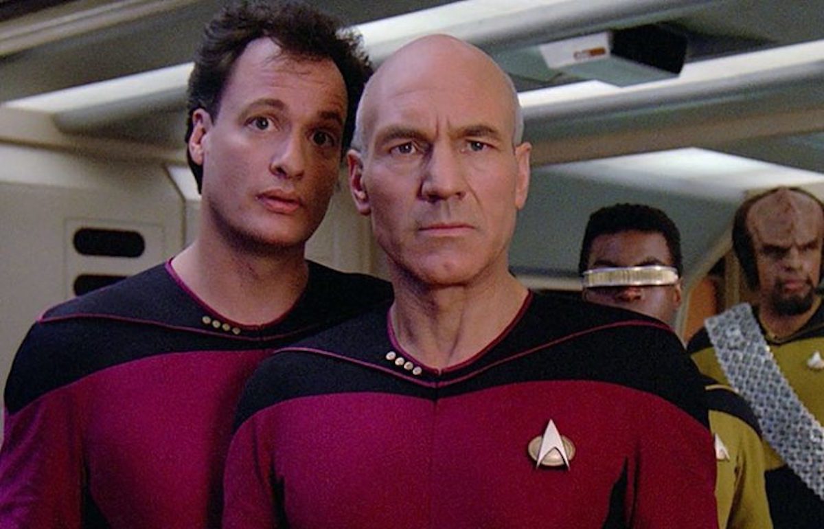 Picard looking concerned while Q whispers torments