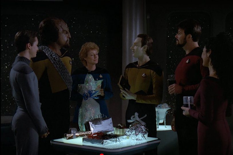 Data opens a gift with the crew