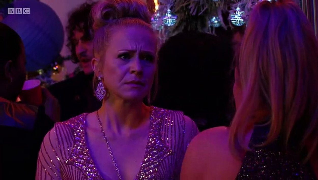 Linda looks desperately sad at a party wearing a pink sparkly dress